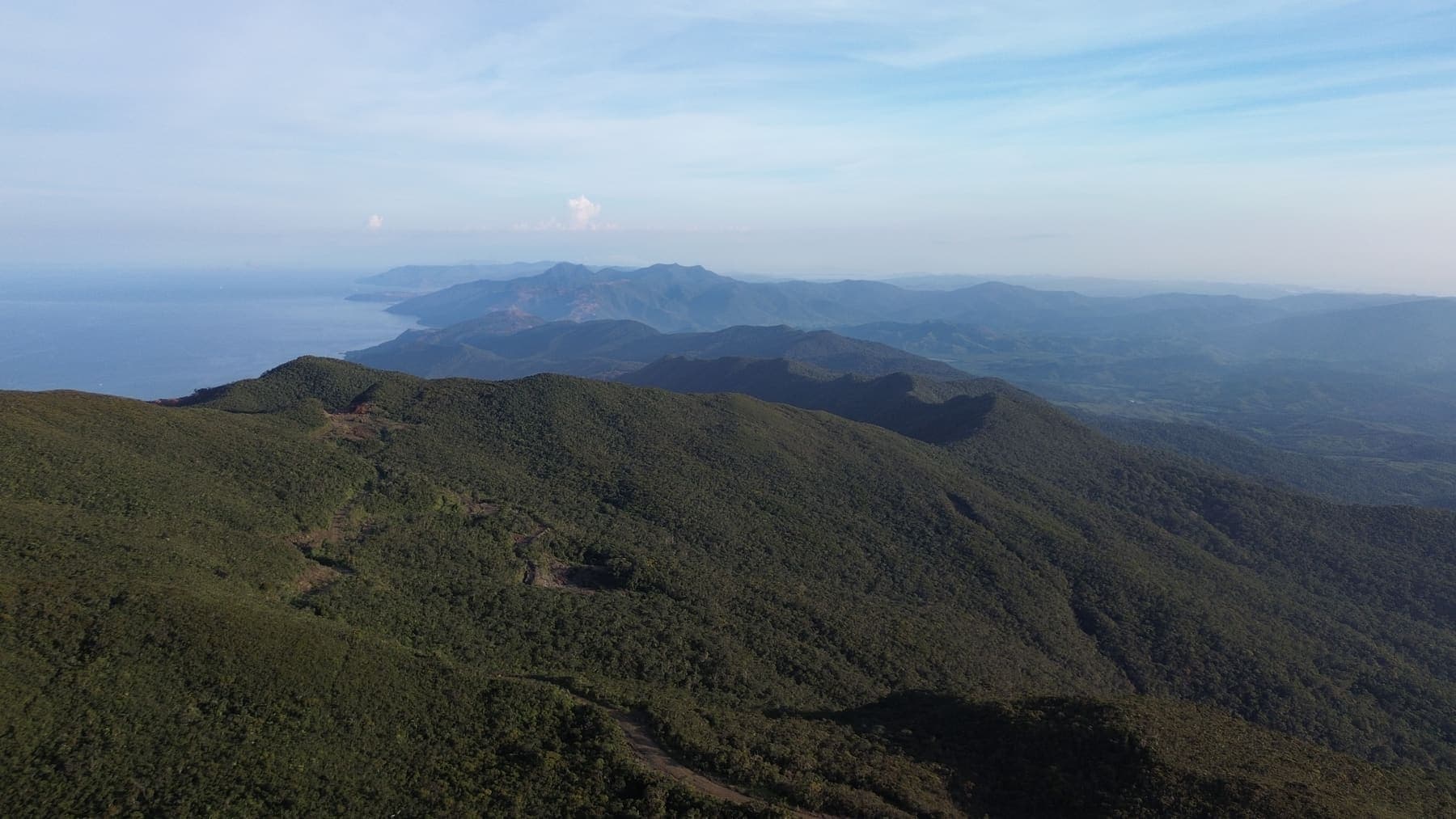 Green mountain ridges running toward the coast under a wide sky in Dinagat Islands