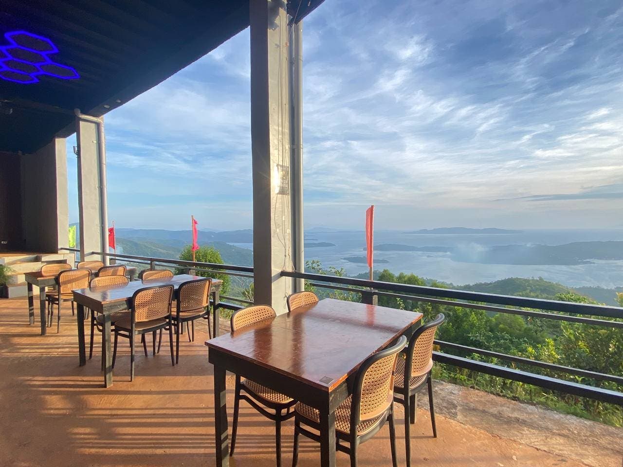The empty Skybar deck in daylight, tables set along a railing looking out over the archipelago